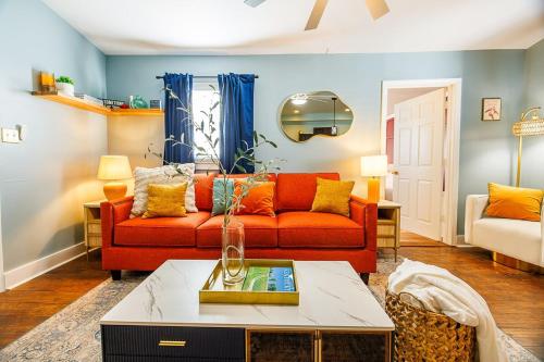 a living room with a red couch and a table at Opulence On Oak Street in Louisville