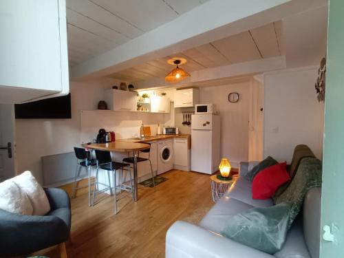 un salon avec un canapé et une cuisine dans l'établissement La P'tite Normande, à Villerville