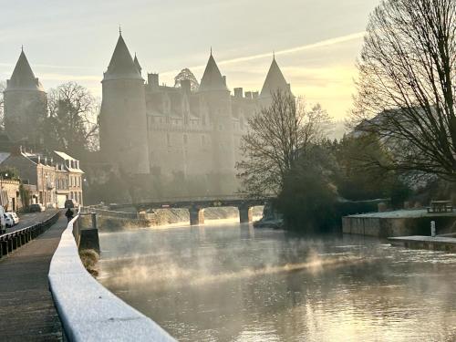 a bridge over a river in front of a castle at Gîte de l Archange in Josselin