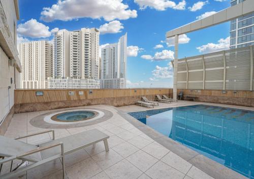 a swimming pool on top of a building with tall buildings at Reem Island Beach Haven with Stellar Balcony Views in Abu Dhabi