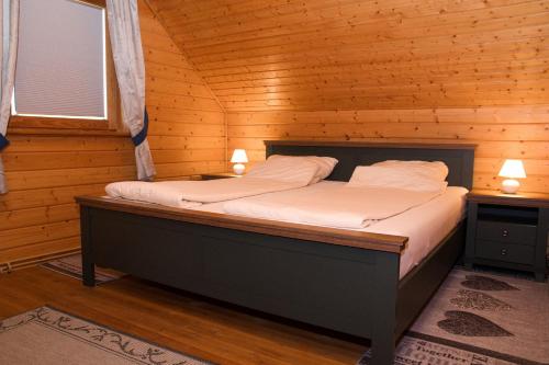 a bedroom with a bed in a wooden cabin at Feriendorf Blauvogel Blauvogel 054 in Hasselfelde