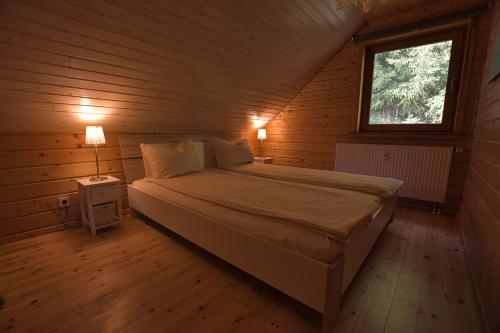 a bedroom with a bed in a wooden cabin at Feriendorf Blauvogel Blauvogel 062 in Hasselfelde