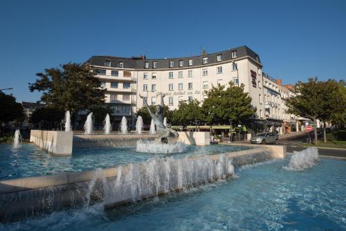 una fuente de agua frente a un edificio en Grand Hotel de la Gare, en Angers