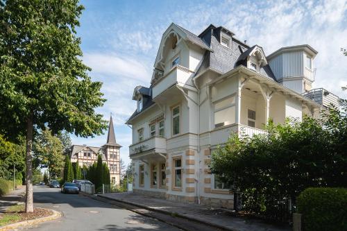 una casa blanca con una torreta en una calle en Maria Luise, en Bad Harzburg