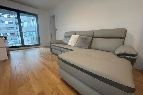 un salon avec un canapé et une grande fenêtre dans l'établissement Spacious appt with balcony in the 13th, à Paris