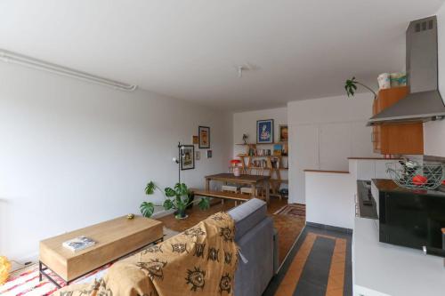 un salon avec un canapé et une cuisine dans l'établissement Charming apartment in Buttes Chaumont, à Paris