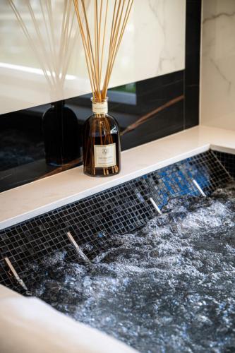 a bottle of whiskey sitting on a bath tub at Gianlica Suites Positano in Positano