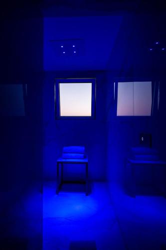 a blue room with a table and two windows at Gianlica Suites Positano in Positano