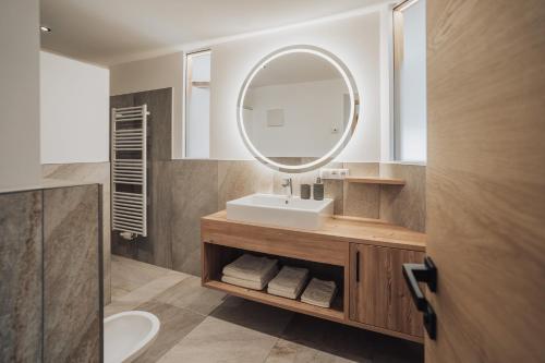 a bathroom with a sink and a mirror at Untermathonhof Vöran - Apartments with Farmyard Experience and homemade Breakfast in Verano