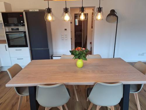 a dining room table with a vase of flowers on it at Ferienwohnung Maison Confortable mit Sonnenterrasse und Garten, Bad Ems, Koblenz, Montabaur, Wandern, Radfahren, Mountanbiketouren in Arzbach