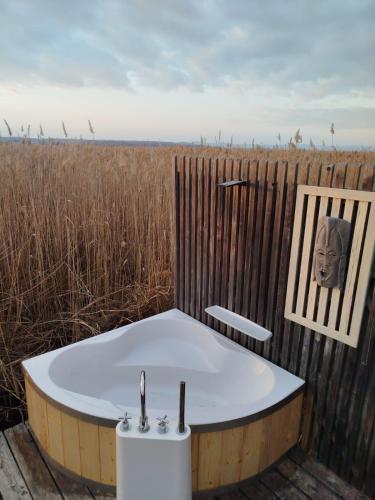 a bath tub in a field with a picture of a head at Pfahlbau Sunset I Toplage Elektroboot inklusive in Rust
