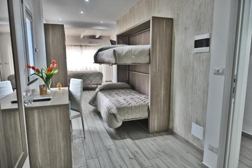 a bedroom with a bunk bed and a desk at B&B Diana in Piazza Armerina