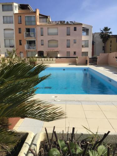 une piscine devant un immeuble dans l'établissement Charmant studio cabine avec piscine, au Cap d'Agde