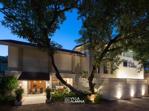 a building with a tree in front of it at Villa ALANNA in Chiang Mai
