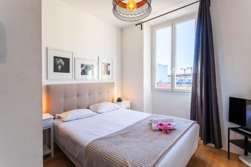 une chambre avec un lit blanc avec des fleurs dessus dans l'établissement Garibaldi AP4447 By Riviera Holiday Homes, à Nice