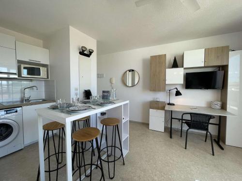une cuisine avec un comptoir avec des tabourets et un évier dans l'établissement Appt 2 pièces LA ROCHELLE - LR030-A310, à La Rochelle
