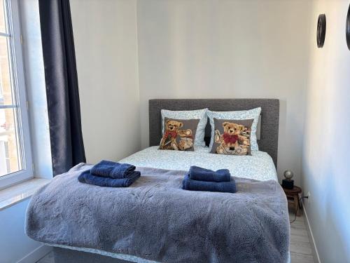 Ένα ή περισσότερα κρεβάτια σε δωμάτιο στο Mulberry duplex bien équipé 2 chambres petite vue sur mer plein centre d'Arromanches à 2 mn de la plage et près de Bayeux