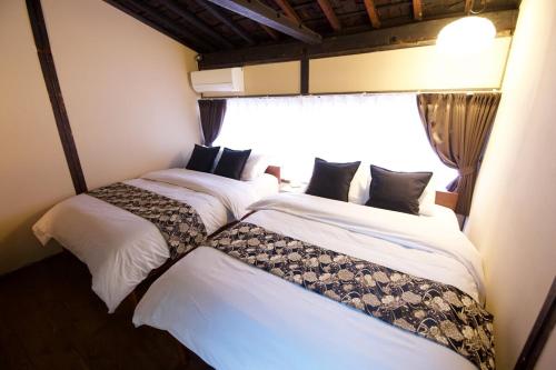 two beds in a room with a window at 飛騨の宿唯 in Takayama