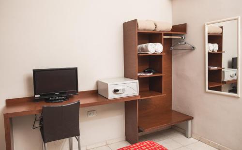 a room with a desk with a tv and a monitor at Gran Hotel Victoria Cordoba Argentina in Cordoba