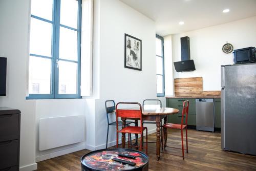 une cuisine avec une table, des chaises et un réfrigérateur dans l'établissement Le Clos Margaux - Vue Cité Médiévale - 3 Chambres, à Carcassonne