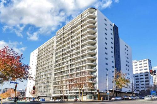 a tall white building on the corner of a street at Aura C two bedrooms apartment balcony good view wi-fi easy parking in Auckland