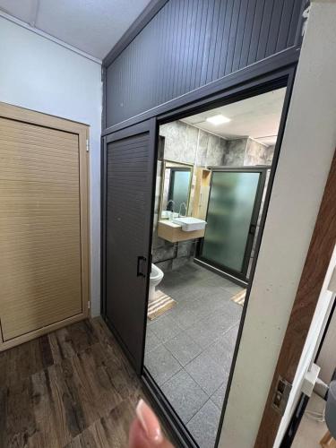 a bathroom with a toilet and a mirror at Horizon Lodge in Diamond Island