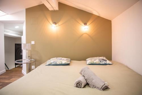 une chambre avec un lit avec deux oreillers dessus dans l'établissement Le Clos Margaux - Vue Cité Médiévale - 3 Chambres, à Carcassonne