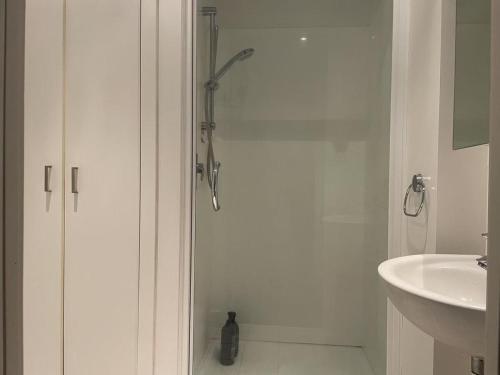 a white bathroom with a shower and a sink at Aura C two bedrooms apartment balcony good view wi-fi easy parking in Auckland