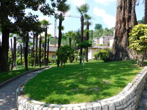 a park with palm trees and a retaining wall at Casa Santa Birgitta in Lugano