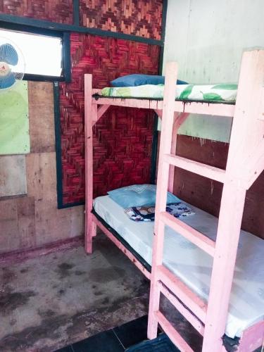2 stapelbedden in een kamer met een bakstenen muur bij sharkbunkbed siargao in General Luna