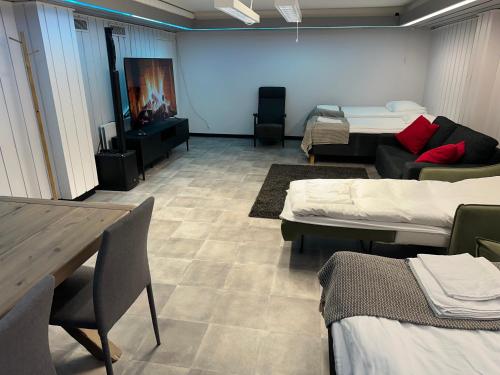 a room with three beds and a table and chairs at Luxury City Apartments, Downtown Loft House with Private Sauna in Rovaniemi