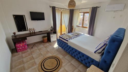 a bedroom with a blue bed and a window at Vila Eclipse Mamaia nord in Mamaia Sat/Năvodari