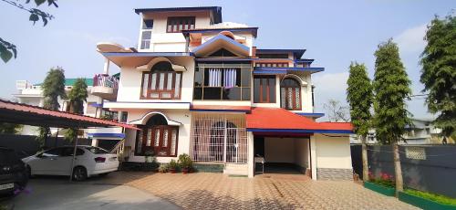 a house with a car parked in front of it at Hazarika's Home in Jorhāt