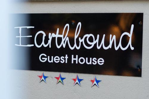 a sign for a cultured guest house with stars at Earthbound Guest House in Oudtshoorn