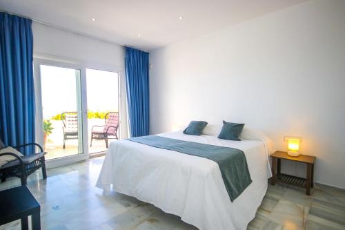 a bedroom with a white bed and a balcony at Three bedroom apartment La Mairena Elviria in La Mairena