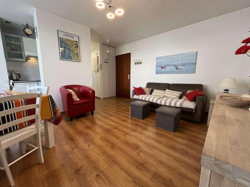 - un salon avec un canapé et un fauteuil rouge dans l'établissement Appartement T2 LA ROCHELLE - LR640-041, à La Rochelle