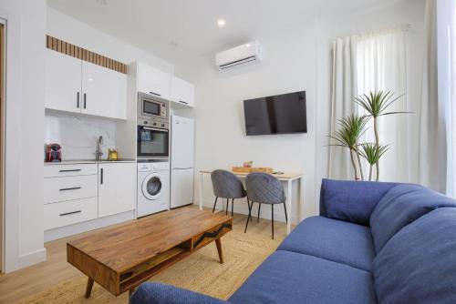 a living room with a blue couch and a table at Dobo Fuenlabrada Lima in Fuenlabrada