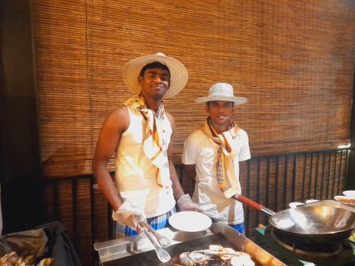 two men wearing hats standing next to a grill at Oak Ray La Ella Breeze in Ella