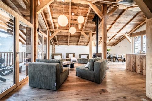 un salon avec des chaises, des tables et des fenêtres dans l'établissement Chalet 4 Mésanges, Saint-Gervais - by EMERALD STAY, à Saint-Gervais-les-Bains