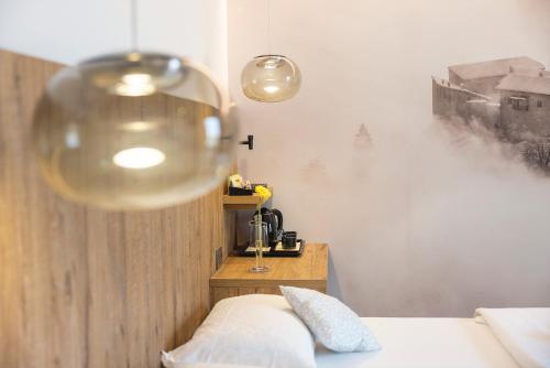 a bedroom with a bed and a wine glass at Hotel Castel Mani in San Lorenzo in Banale
