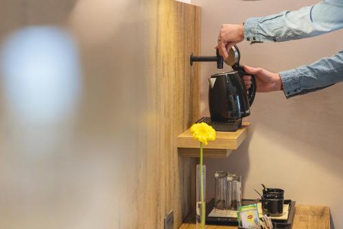 a person is putting a camera on a shelf in a room at Hotel Castel Mani in San Lorenzo in Banale