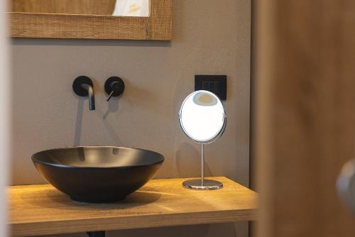 a bowl on top of a table with a mirror at Hotel Castel Mani in San Lorenzo in Banale