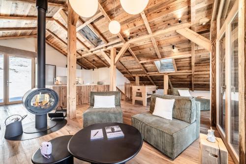 - un salon avec des plafonds en bois, une table et des chaises dans l'établissement Chalet 4 Mésanges, Saint-Gervais - by EMERALD STAY, à Saint-Gervais-les-Bains