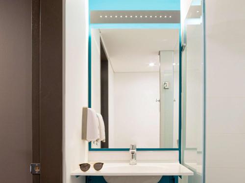 a bathroom with a sink and a mirror at ibis budget Bogota Marly in Bogotá
