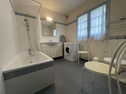 La salle de bains est pourvue d'une baignoire, d'un lavabo et d'un lave-linge. dans l'établissement Maison 4 pièces LA ROCHELLE - LR000-019, à La Rochelle