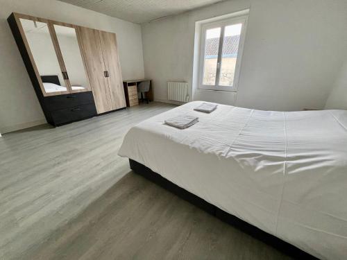 une chambre avec un grand lit blanc et un miroir dans l'établissement L 'Échappée du Clain, à Poitiers