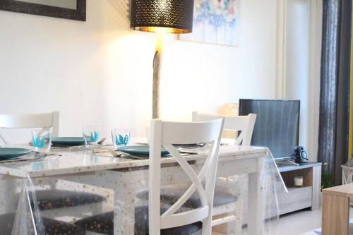 une table à manger avec une lampe et des chaises blanches dans l'établissement Appt 3 pièces LA ROCHELLE - LR520-046, à La Rochelle