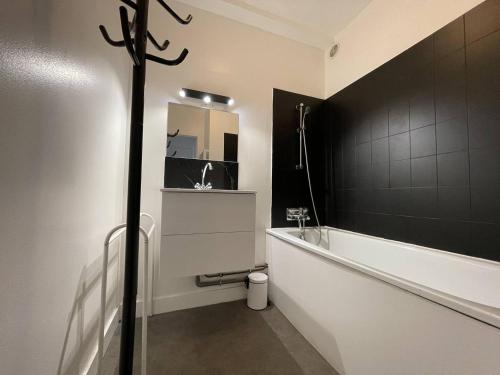 une salle de bain avec une baignoire et un lavabo dans l'établissement Appt 1 pièce LA ROCHELLE - LR820-0D2, à La Rochelle