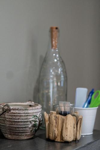 a glass bottle sitting next to a table with a container at Earthbound Guest House in Oudtshoorn