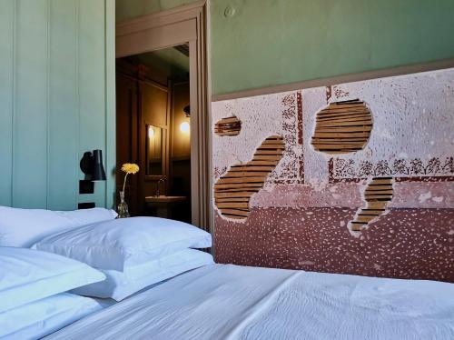 a bedroom with two beds and a brick wall at 1900 Hotel in Symi